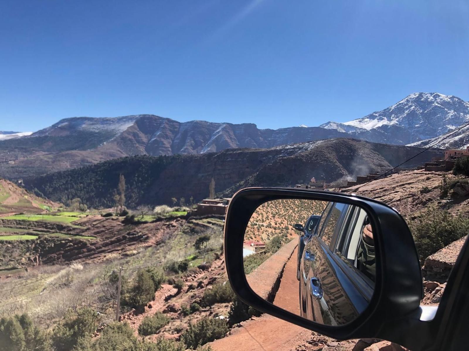 The snow-capped High Atlas seen from inside our 4x4, terraced fields dropping into the valley